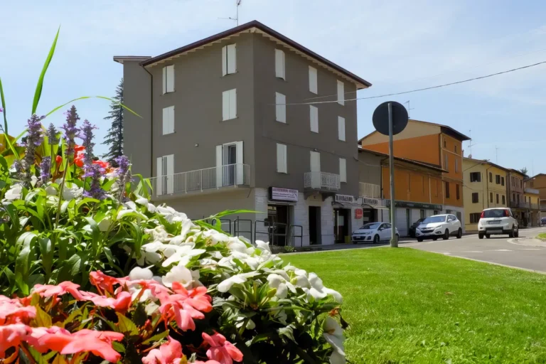 Edificio residenziale costruito da Impref in contesto urbano con area verde e fiori