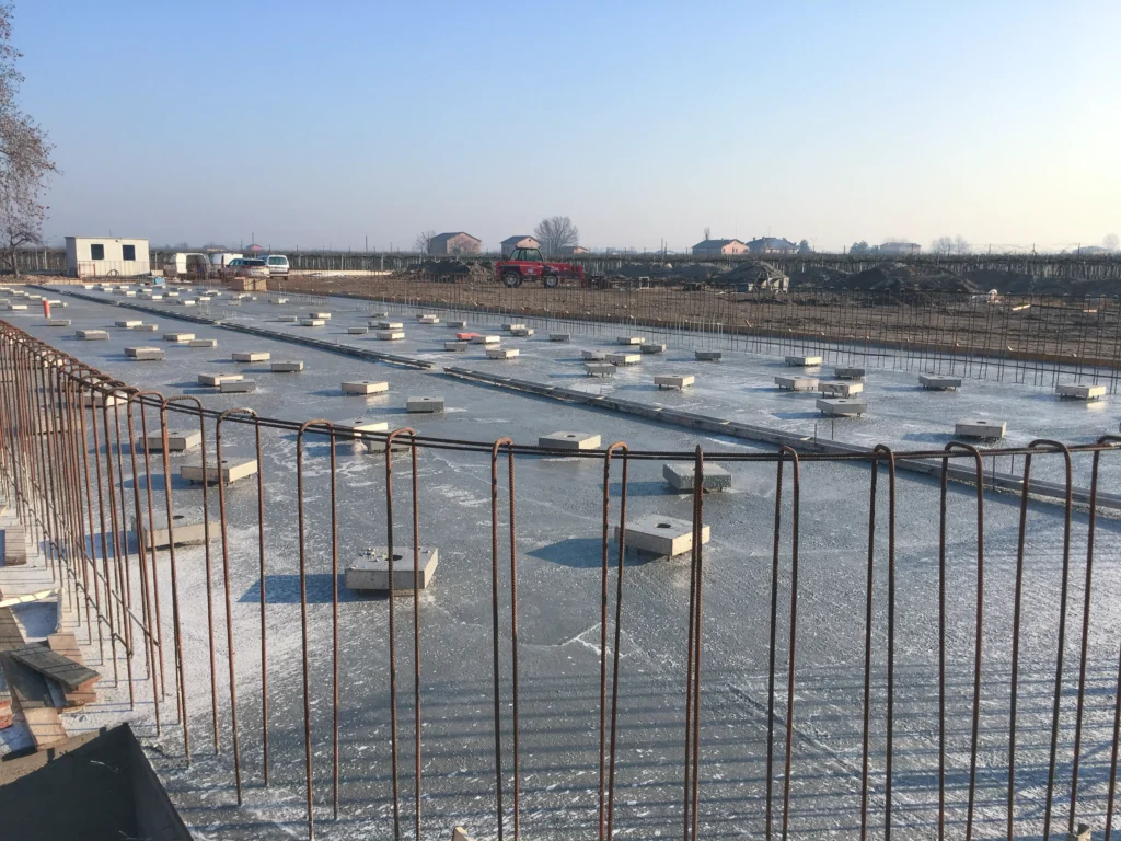 Cantiere per impianto industriale con silos di stoccaggio e area produttiva in costruzione realizzato da Impref