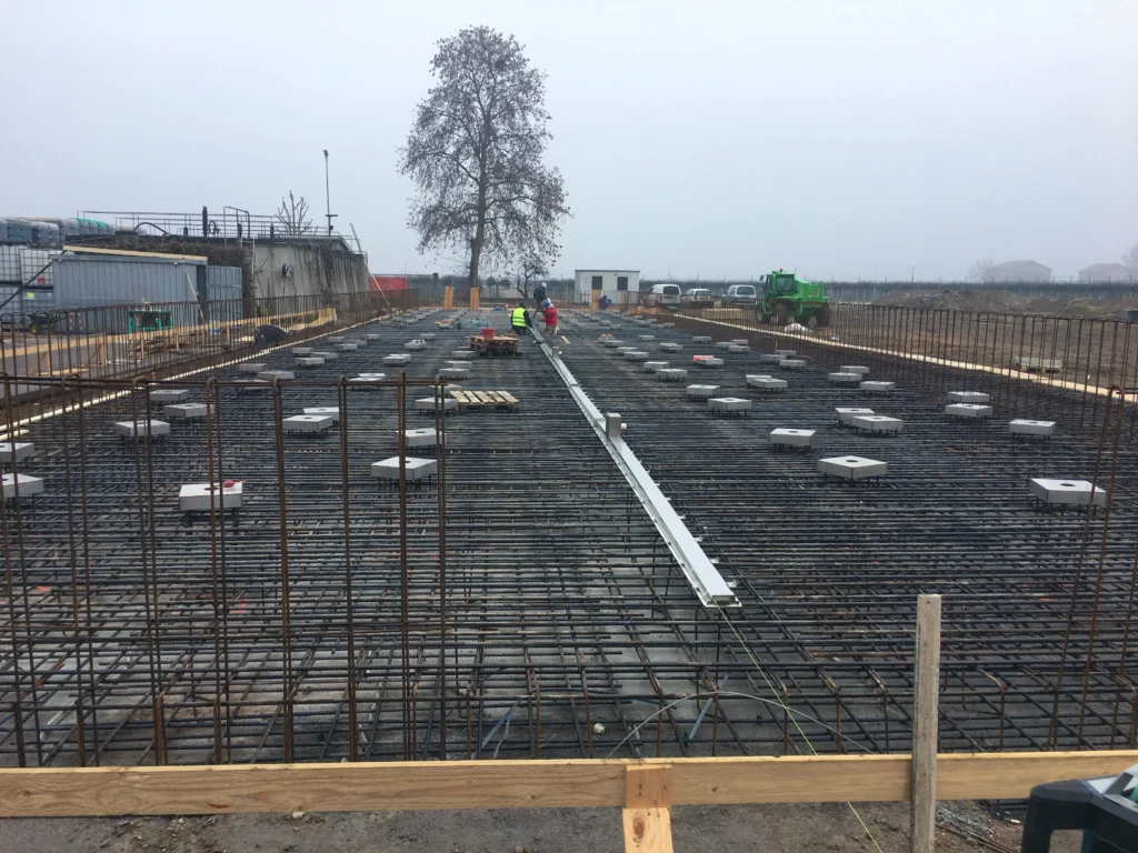 Cantiere per impianto industriale con silos di stoccaggio e area produttiva in costruzione realizzato da Impref