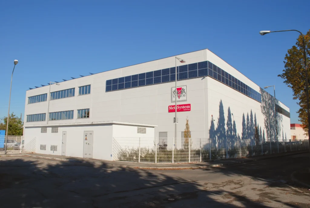 Edificio industriale bianco con ampie finestre e area esterna