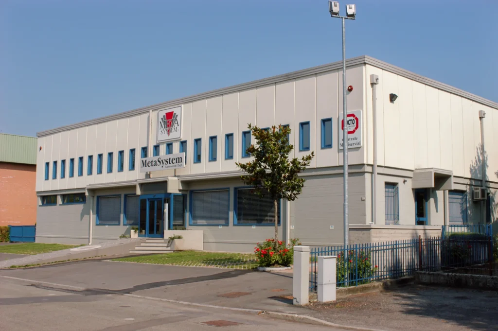 Edificio industriale bianco con ampie finestre e area esterna